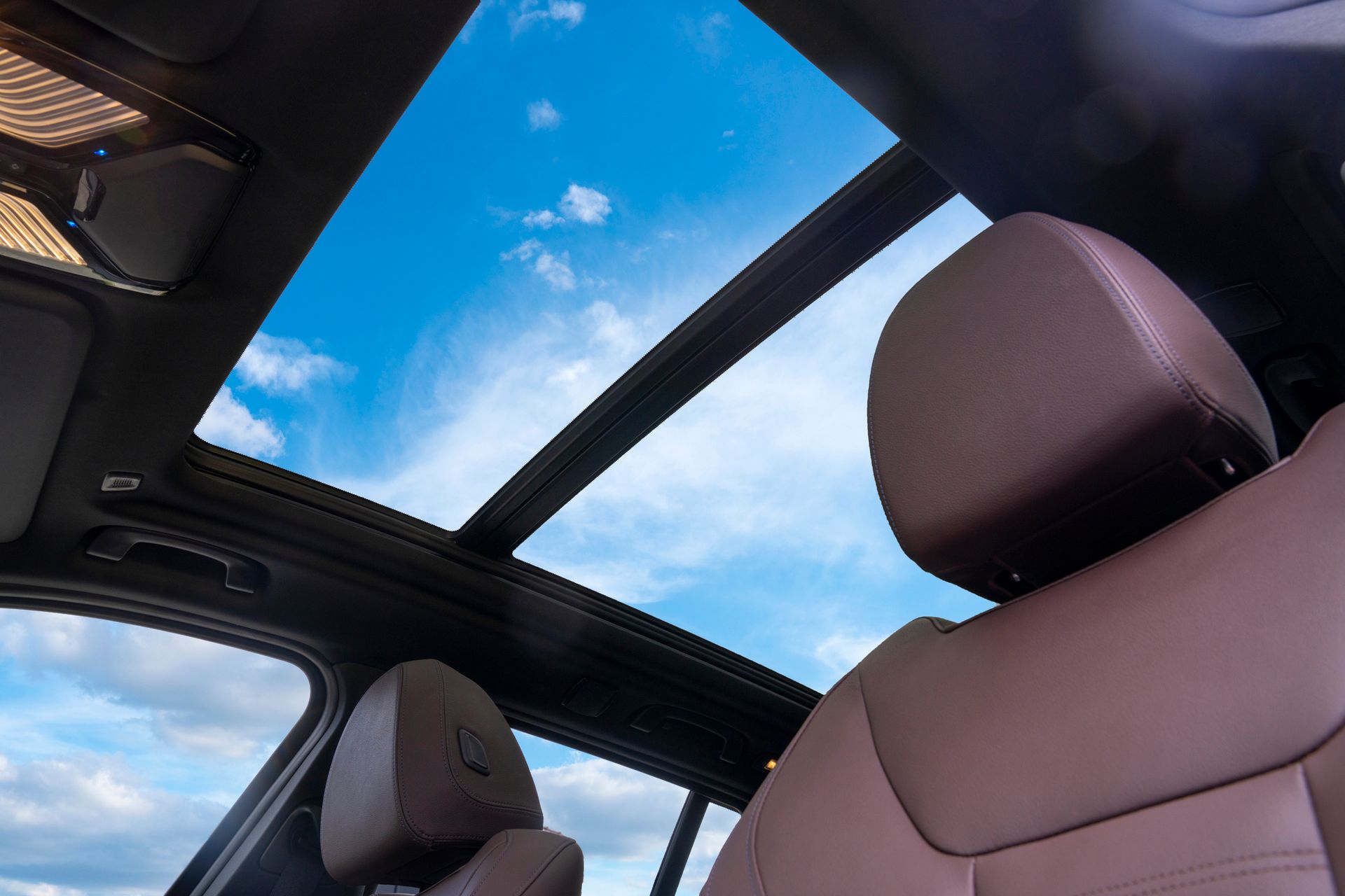Looking up at the sky through the sunroof of a car.