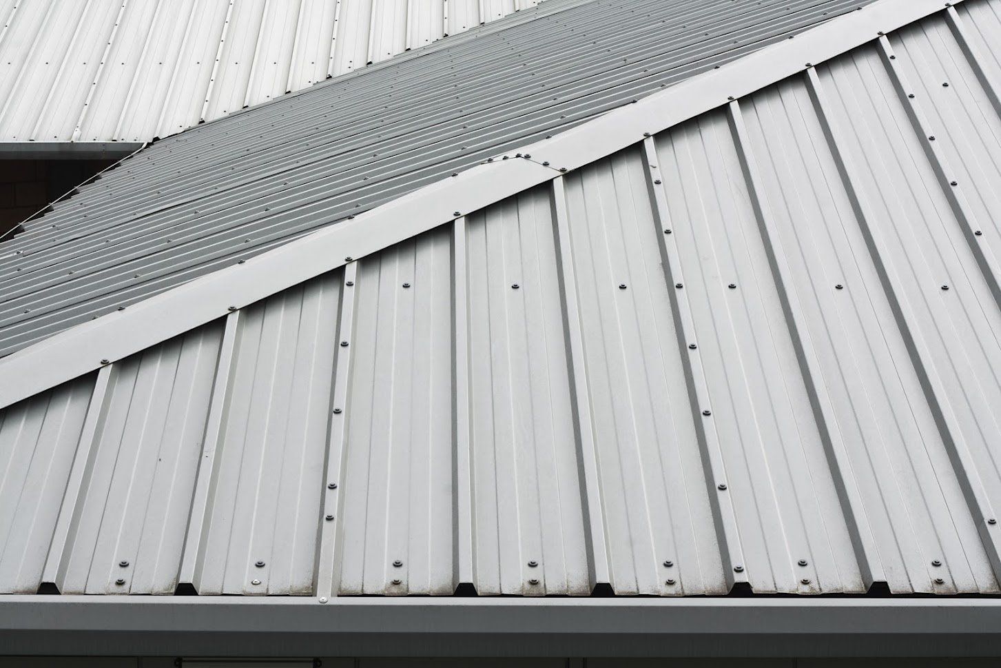 Metal roof with vertical panels and a textured section.