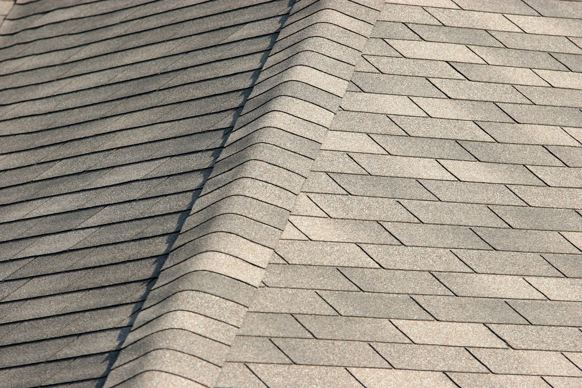 Gray asphalt shingles on a roof peak.