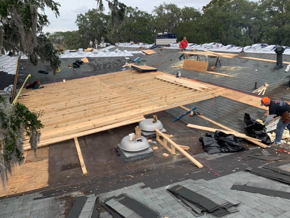 Roofing crew framing new rafters during a shingle roof replacement Roofing crew framing new rafters during a shingle roof replacement
