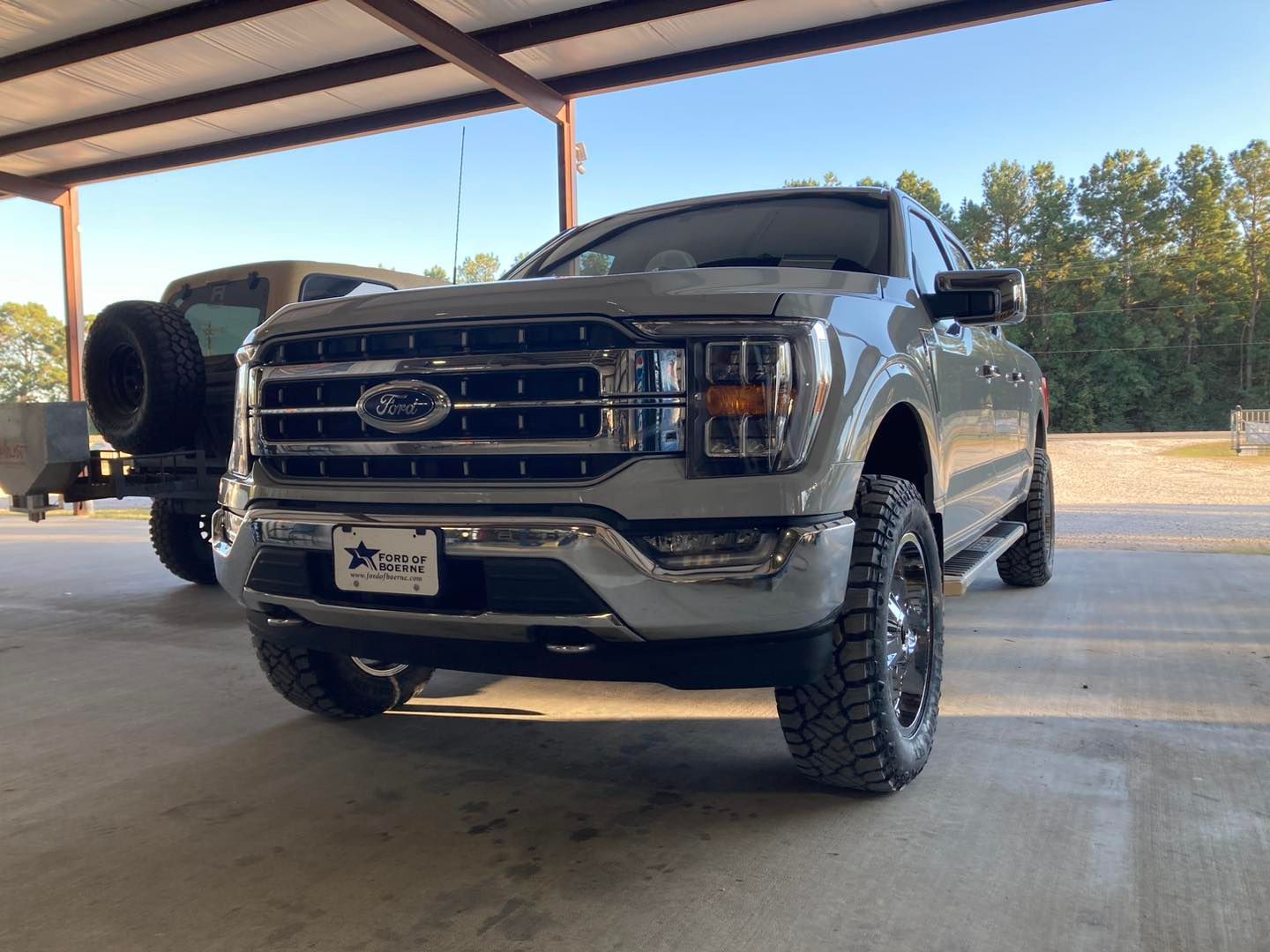 Silver Ford pickup truck parked under a covered outdoor area, front view.