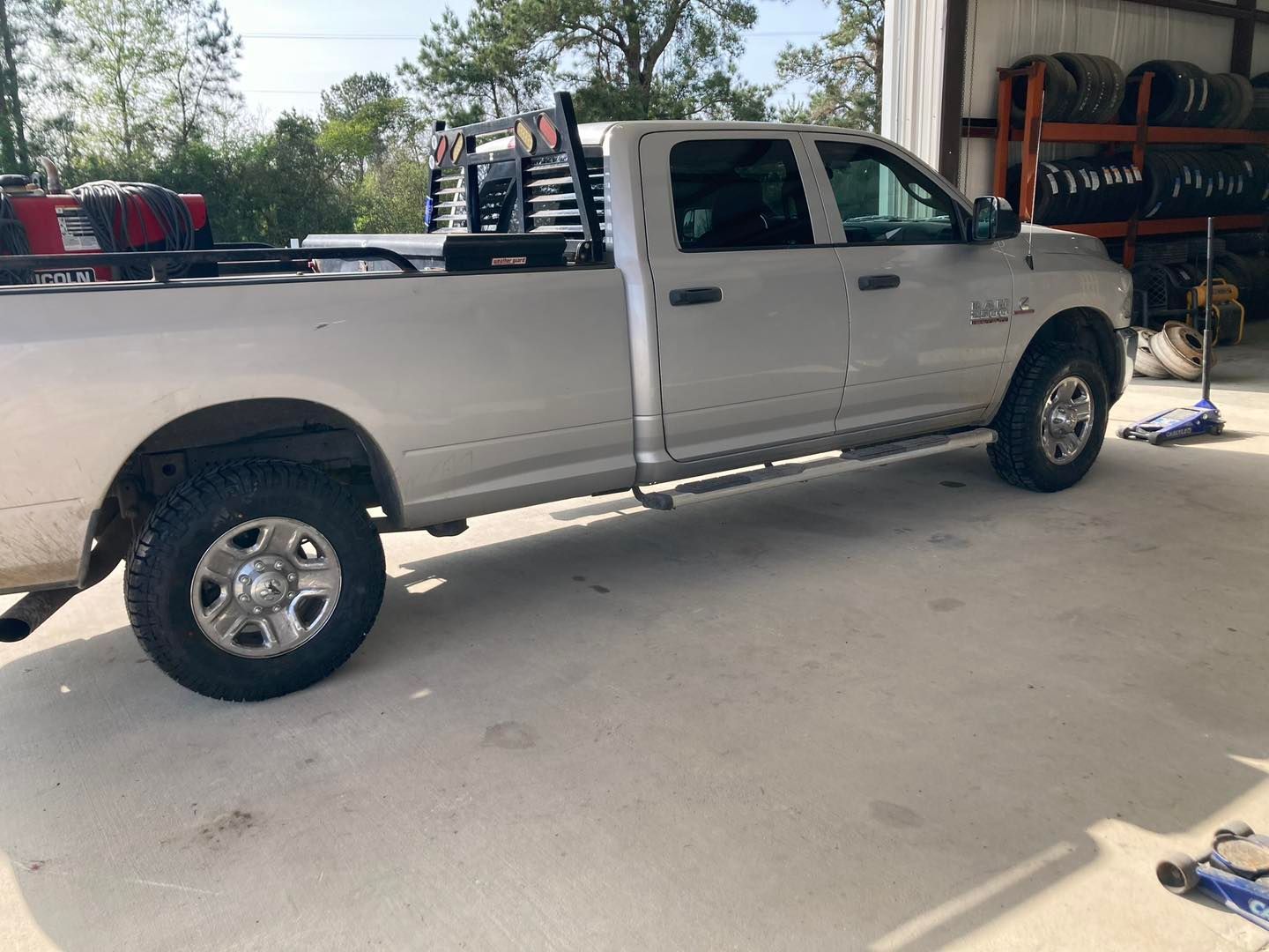 Silver pickup truck parked in a garage with tools and equipment around it