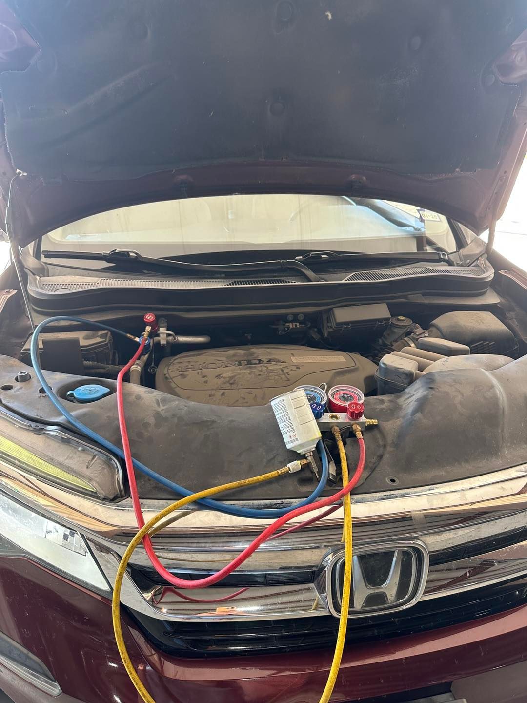 Car engine bay open with battery cables connected for jump-start or diagnostics