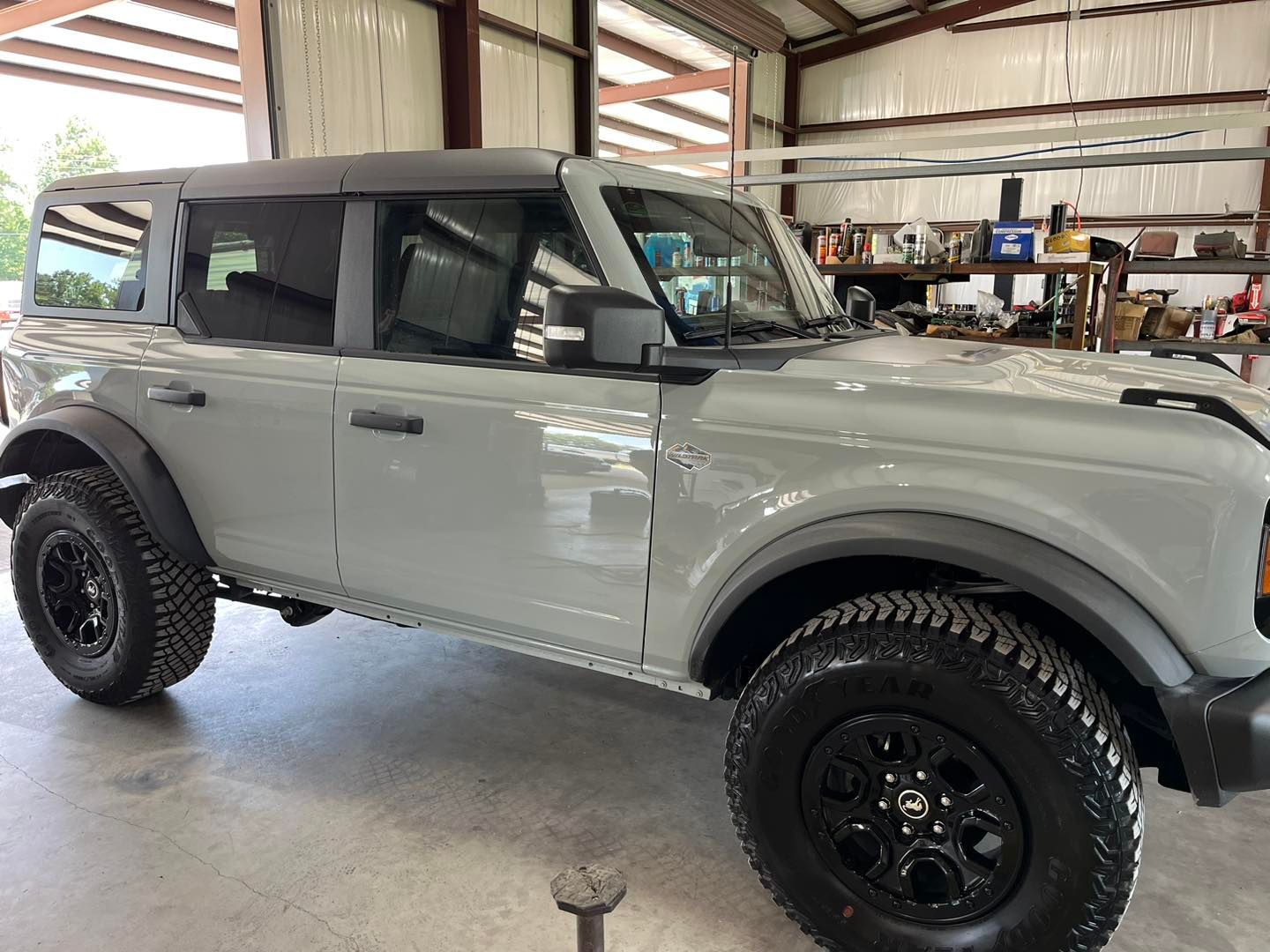 White lifted SUV with black wheels parked inside a garage or workshop