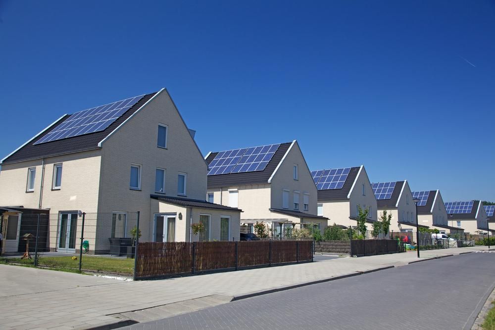 A Row Of Houses With Solar Panels On The Roofs — Mission Solar And Electrical In Mission Beach, QLD