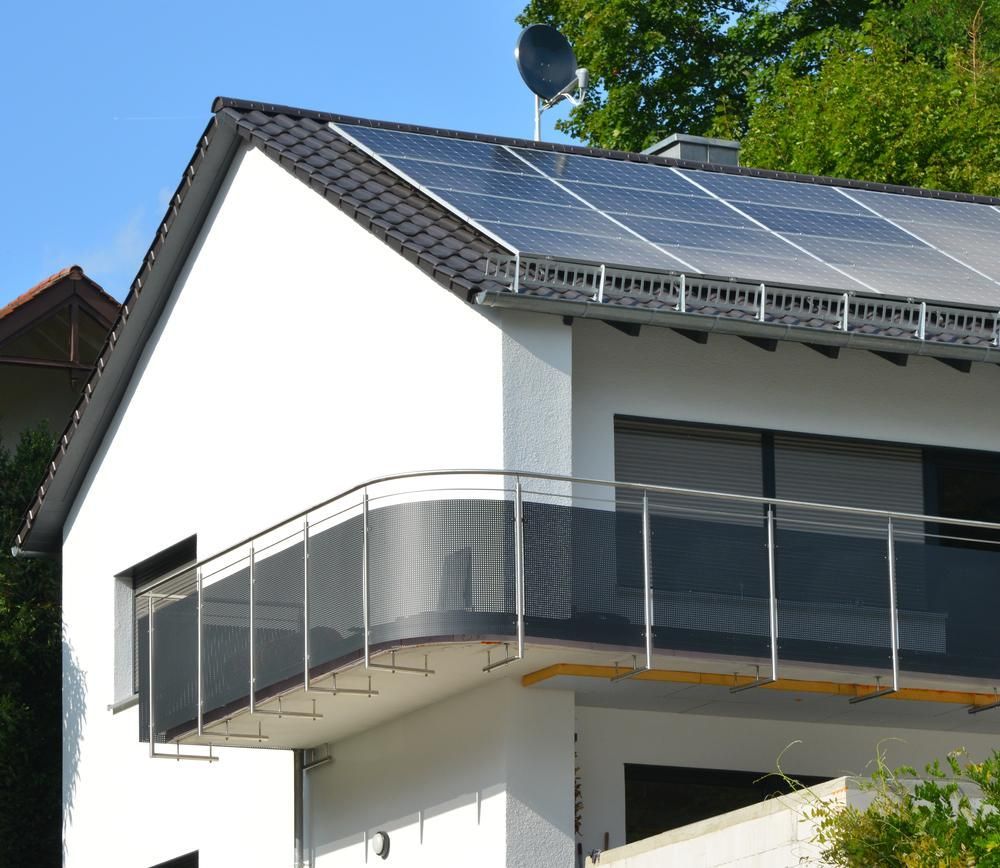 A White House With A Balcony And Solar Panels On The Roof — Mission Solar And Electrical In Cardwell, QLD