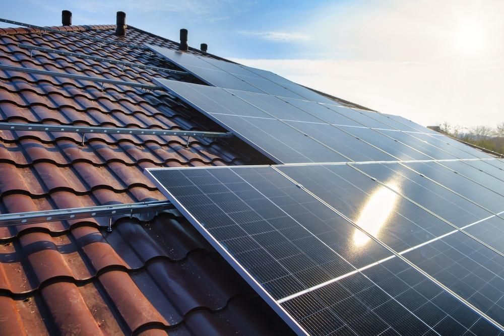 A Row Of Solar Panels Sitting On Top Of A Tiled Roof — Mission Solar And Electrical In Innisfail, QLD