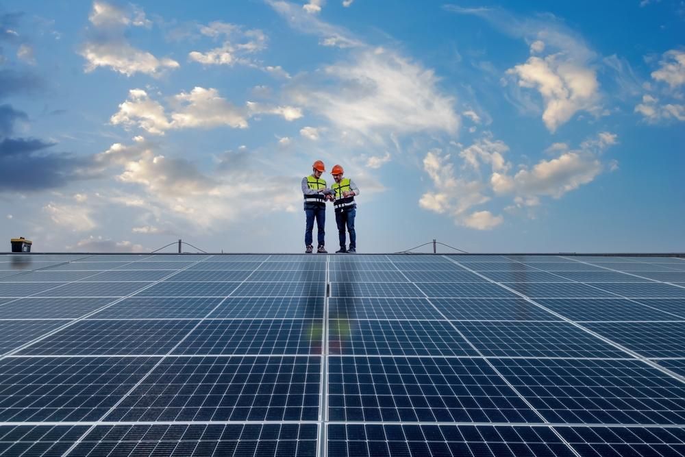 Two Men Are Standing On Top Of A Solar Panel Field — Mission Solar And Electrical In Innisfail, QLD