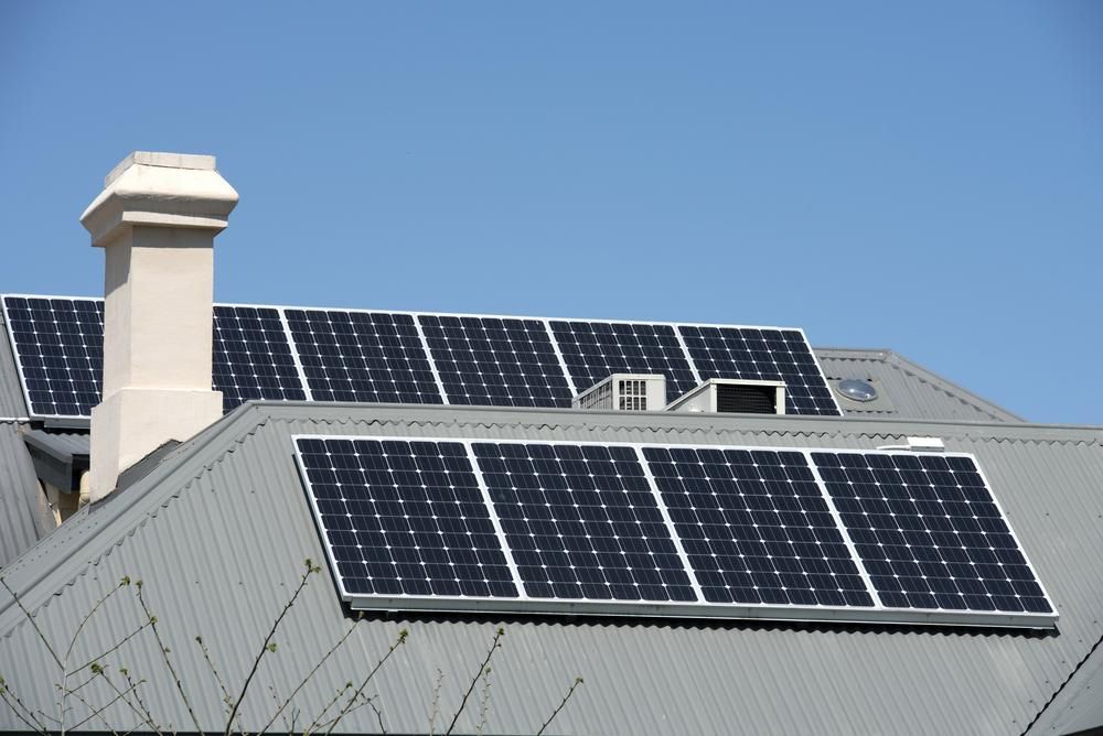A Roof With Solar Panels And A Chimney On It — Mission Solar And Electrical In Tully, QLD
