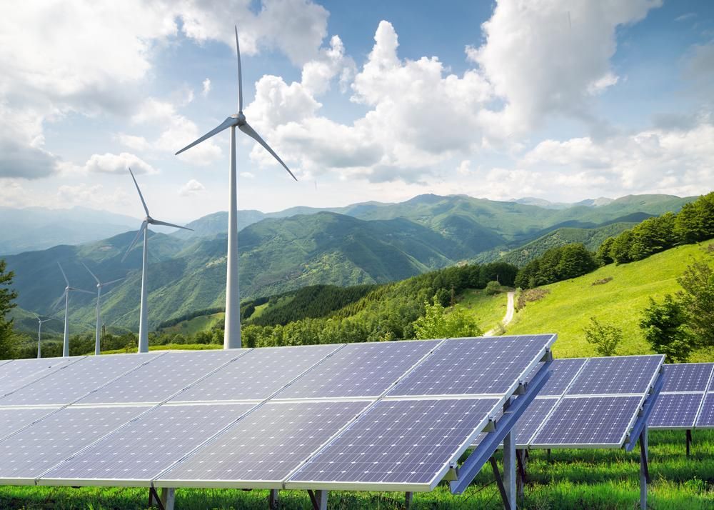 A Field Of Solar Panels And Wind Turbines With Mountains In The Background — Mission Solar And Electrical In Cardwell, QLD
