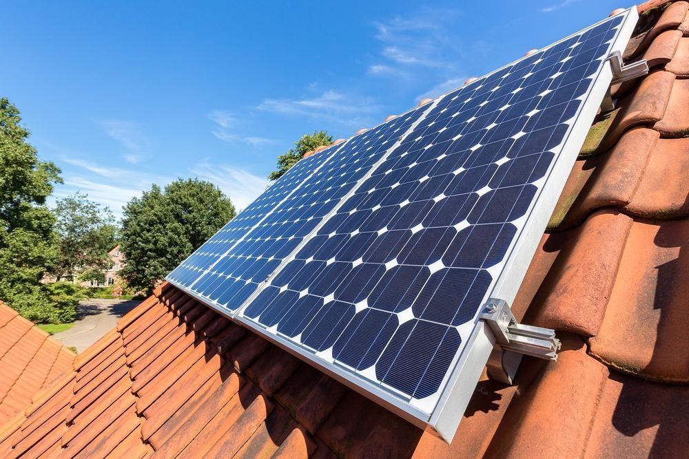 A Row Of Solar Panels Sitting On Top Of A Tiled Roof — Mission Solar And Electrical In Cardwell, QLD