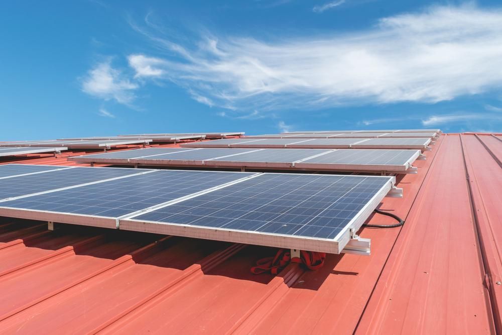 A Row Of Solar Panels On Top Of A Red Roof — Mission Solar And Electrical In Cardwell, QLD