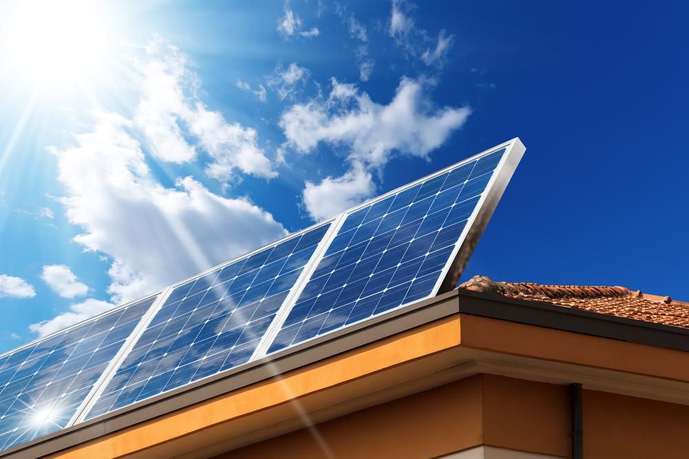 The Sun Is Shining Through The Solar Panels On The Roof Of A House — Mission Solar And Electrical In Tully, QLD