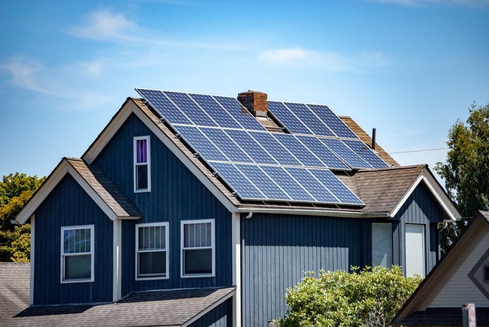 A Blue House With Solar Panels On The Roof — Mission Solar And Electrical In Mission Beach, QLD