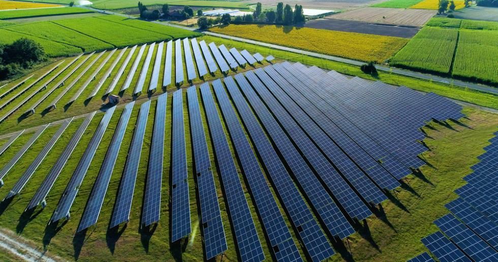 An Aerial View Of A Row Of Solar Panels In A Field — Mission Solar And Electrical In Mission Beach, QLD