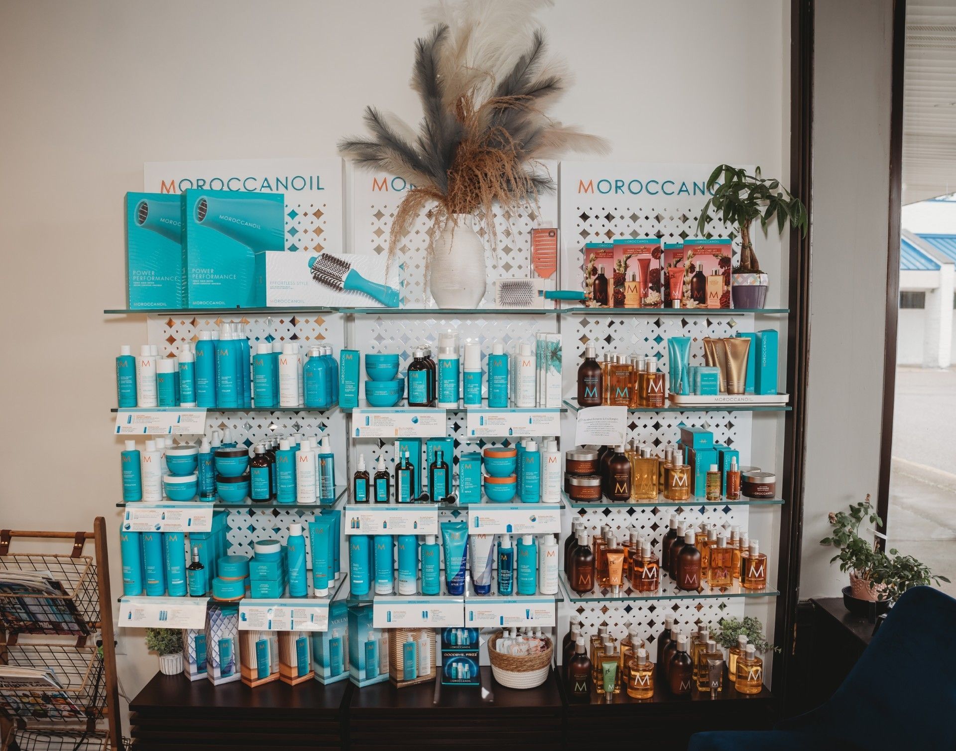 Shelf display of Moroccanoil hair products in shades of blue, teal, and brown.