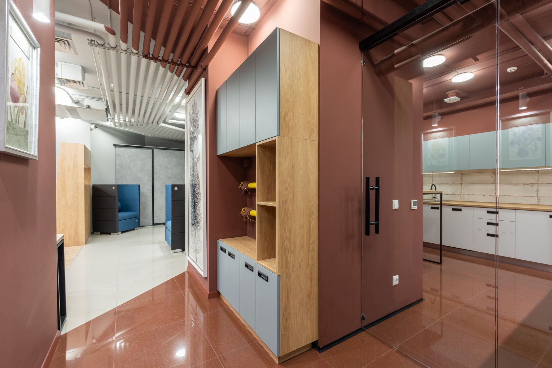 Modern office hallway with wood cabinets, glass walls, and glossy brown flooring