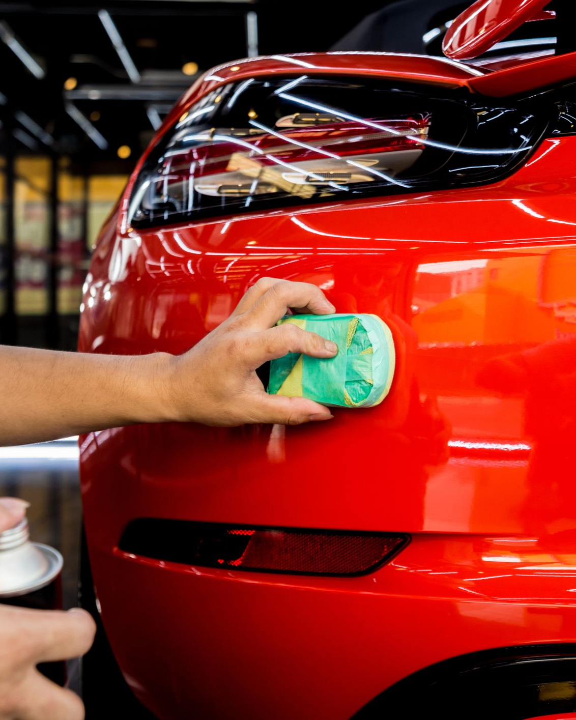 A person is wrapping a car with clear plastic