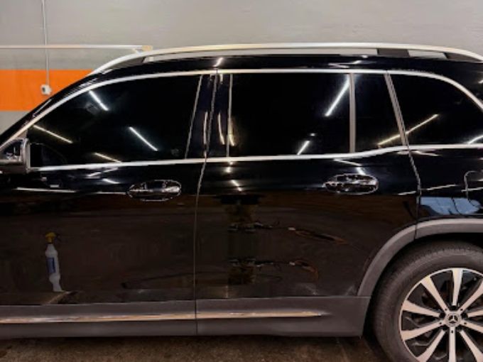 Black Mercedes SUV in a garage showing deep dark window tint across all side windows