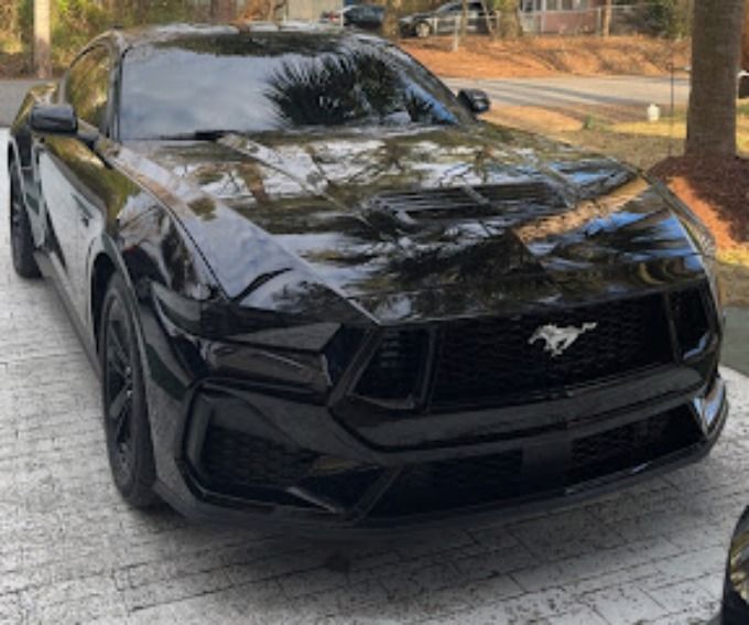 Black Ford Mustang parked outdoors with a deep glossy shine after ceramic coating service