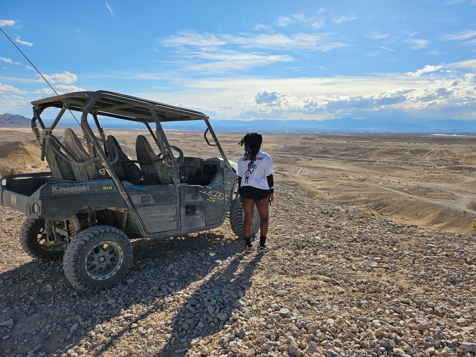 Girl looking the desert next to an UTV