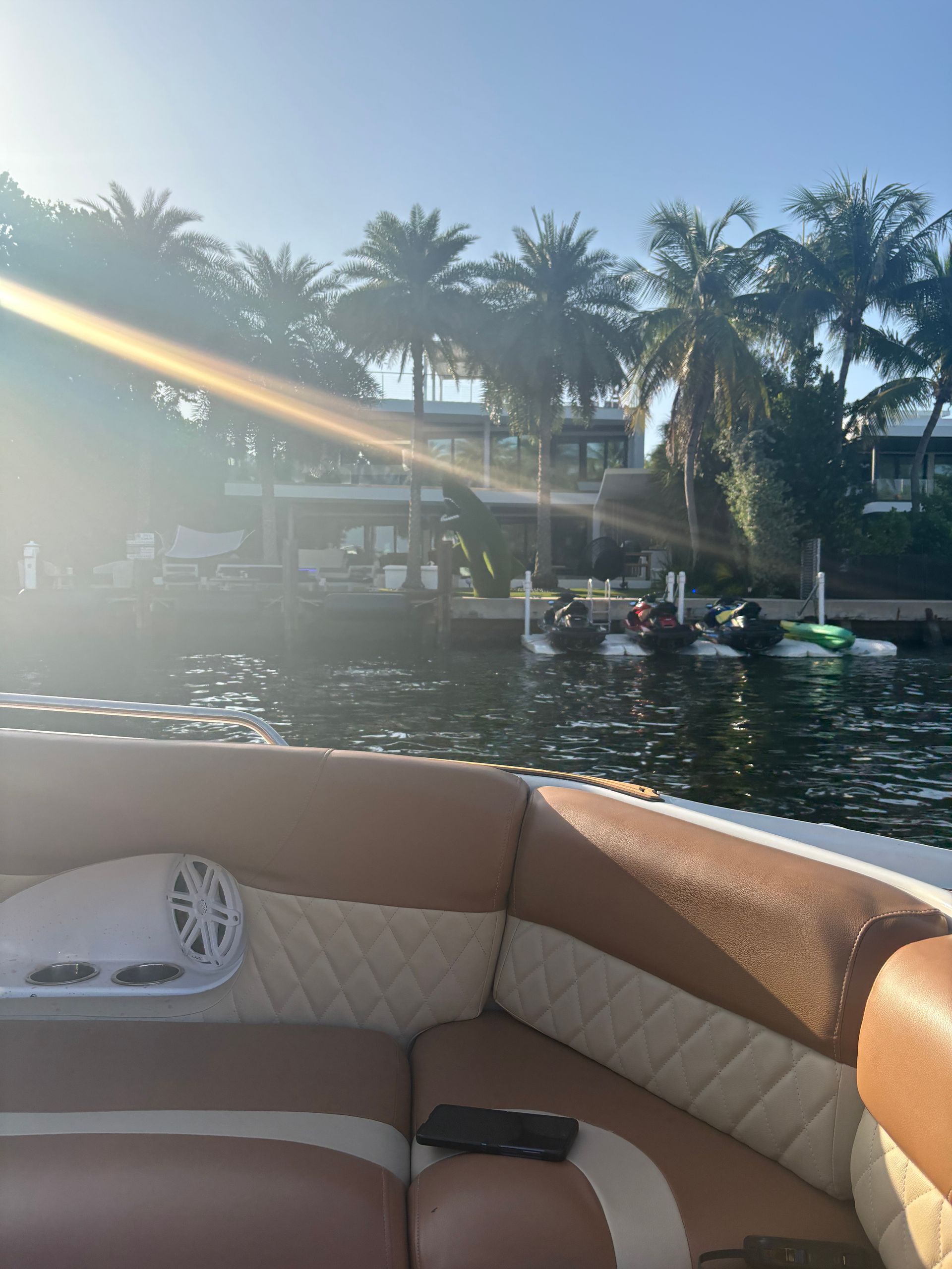 Private boat tour in Miami cruising past waterfront homes and palm trees