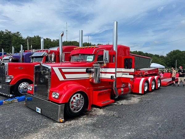 A row of red semi trucks parked in a parking lot