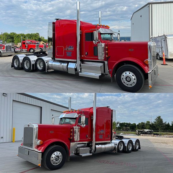 A red semi truck is parked in front of a garage