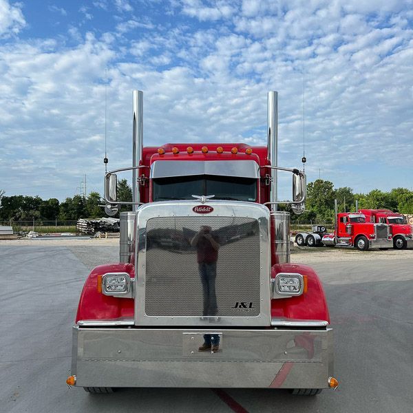 A red semi truck is parked in a parking lot