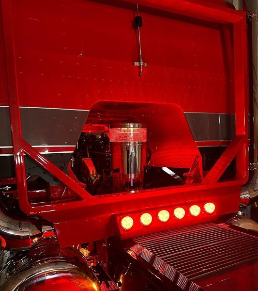 The back of a red truck with the hood open.