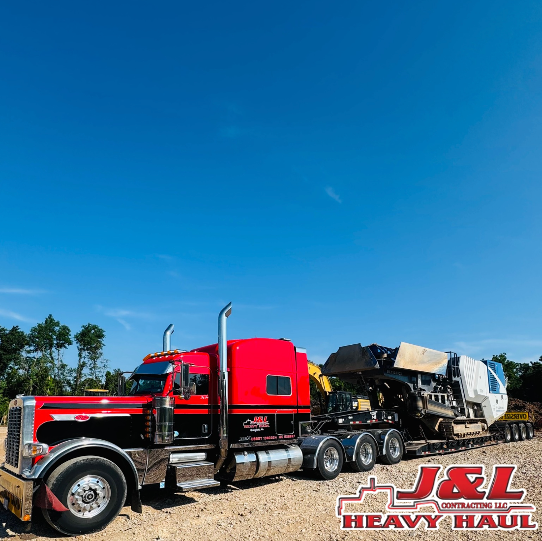 A red semi truck is parked on the side of the road.