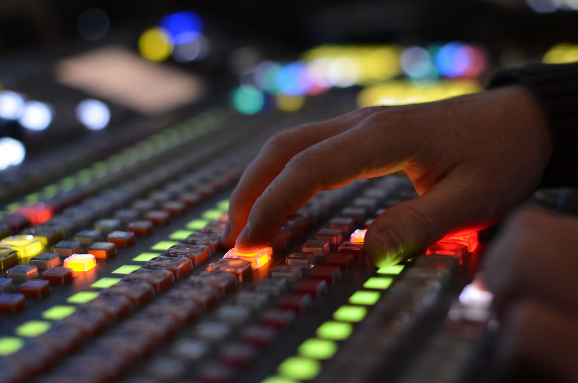 A person 's hand is pressing a button on a control panel.