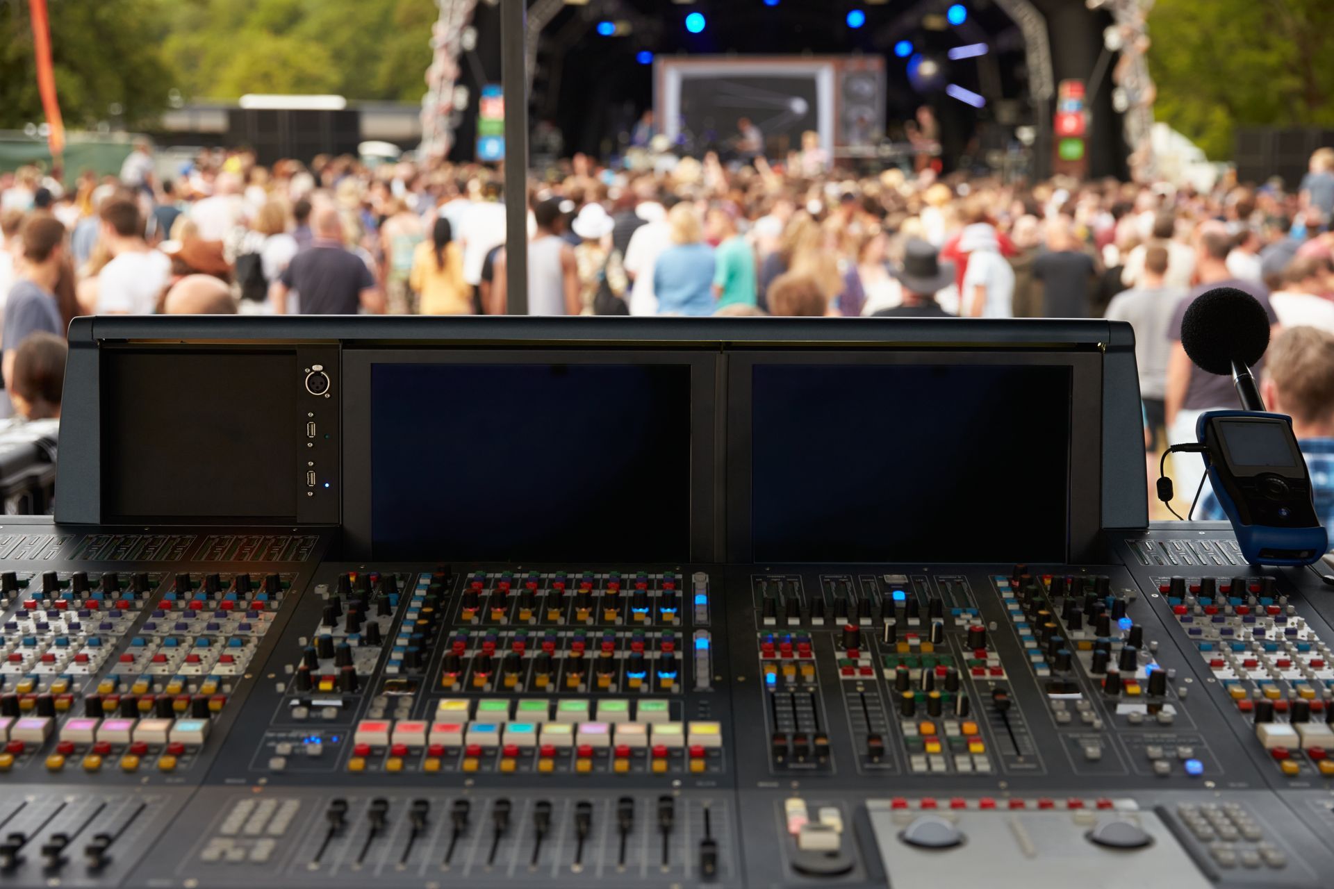 A large crowd of people are watching a concert on a stage.