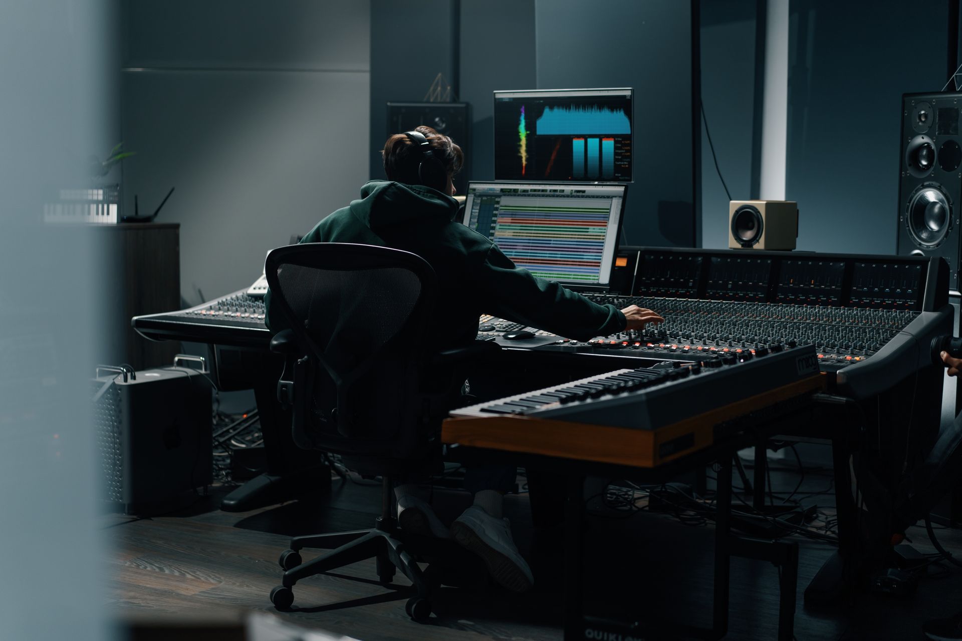 A man is sitting at a desk in a recording studio.