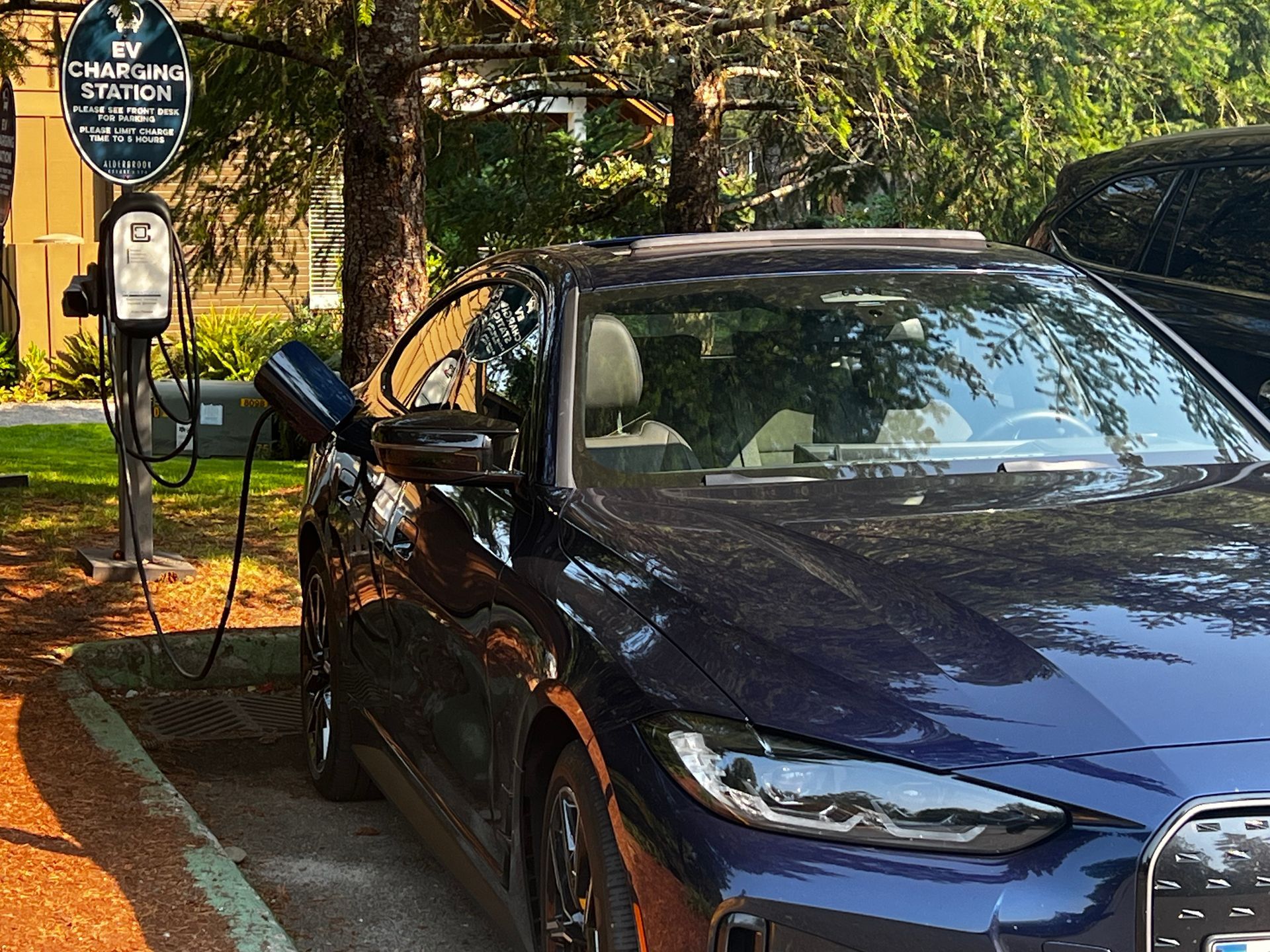 A blue car is being charged at a charging station.