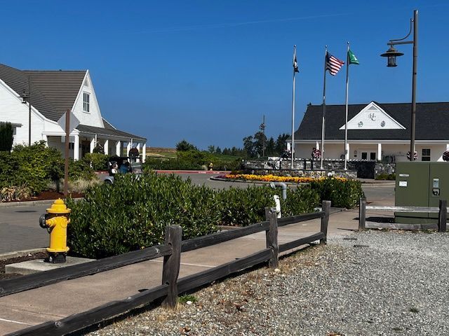 A yellow fire hydrant is next to a wooden fence