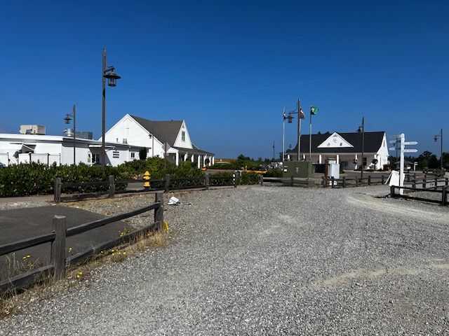A gravel road leading to a row of white houses.