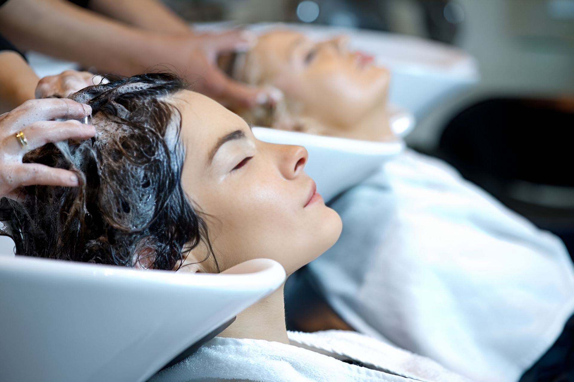 Two Women Are Getting Their Hair Washed In A Salon — Carlee Hair Design In Anula, NT