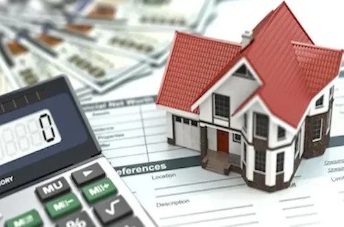 A calculator, a house miniature, some printed documents and money bills