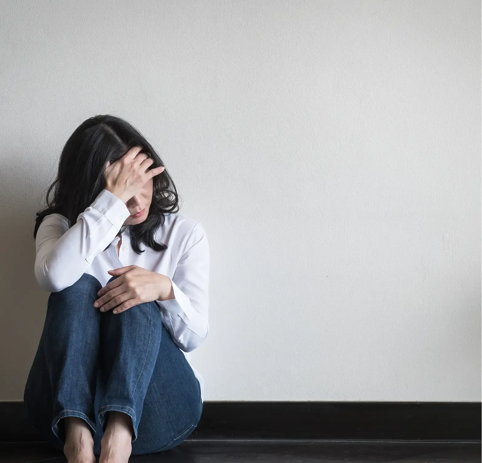 A distressed woman holding her forehead.