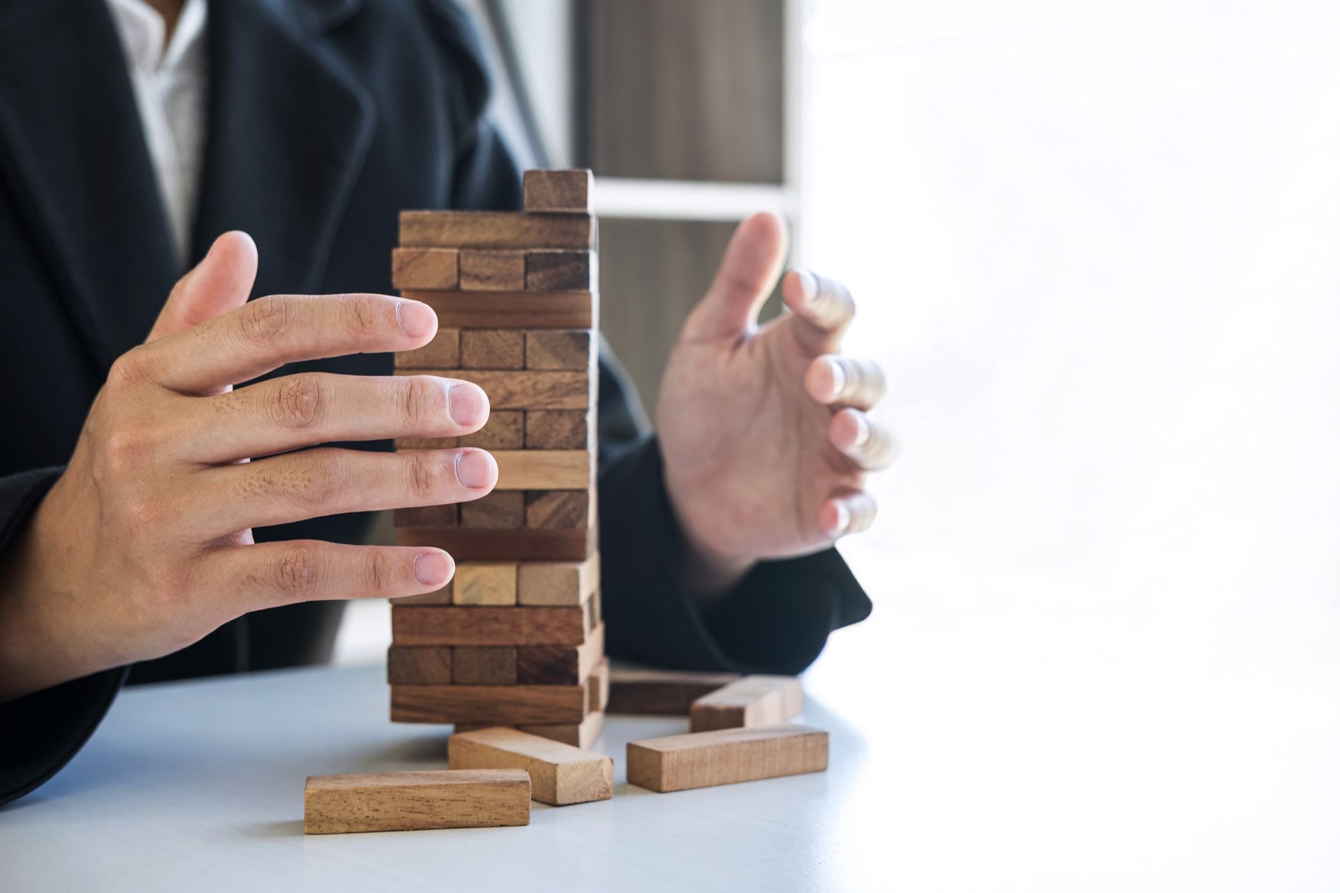 Stack of blocks with hands ensuring its stability