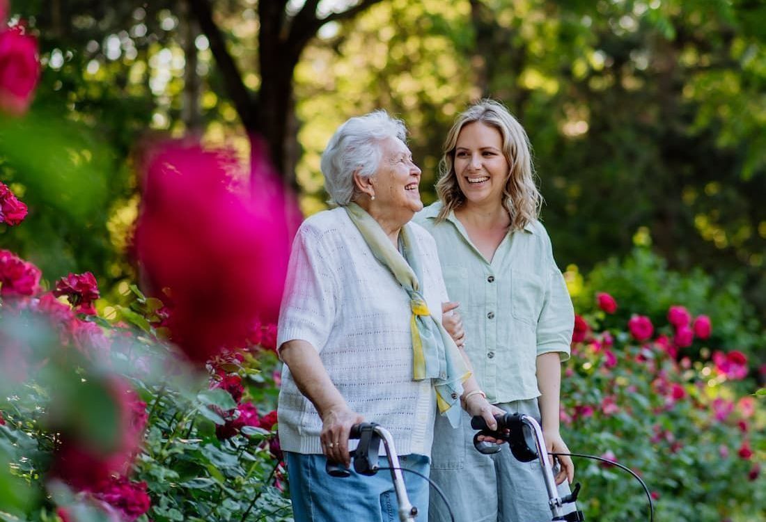 Elderly woman with younger woman in a garden