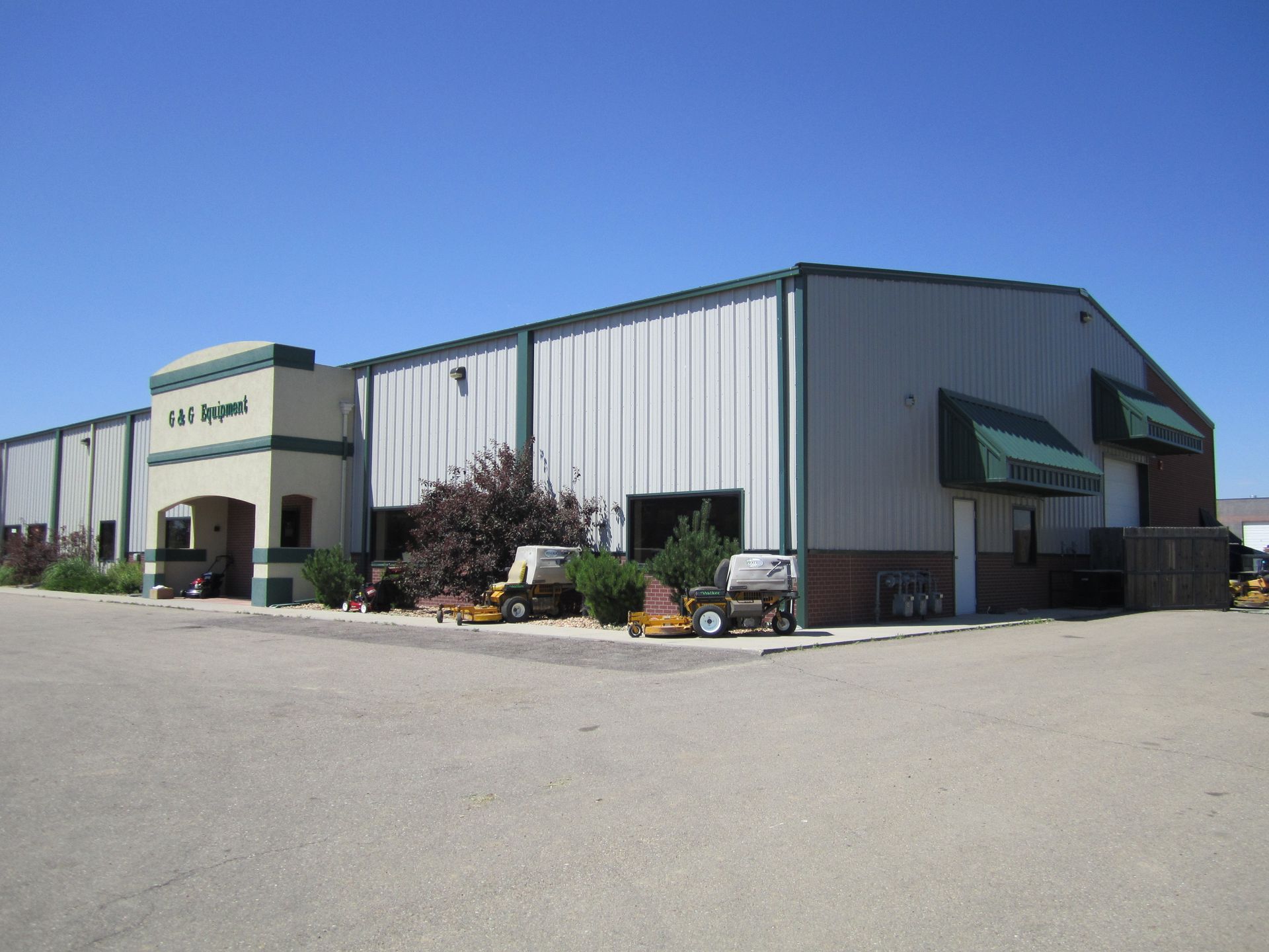 Large industrial warehouse building with metal siding and a clear blue sky
