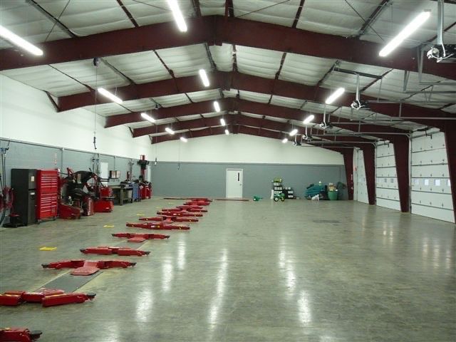 Large empty warehouse with red fire equipment and a polished concrete floor