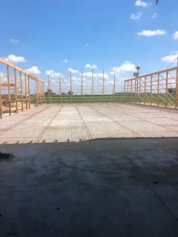 Interior view of a building under construction, showing wooden frames, wiring, and ductwork.
