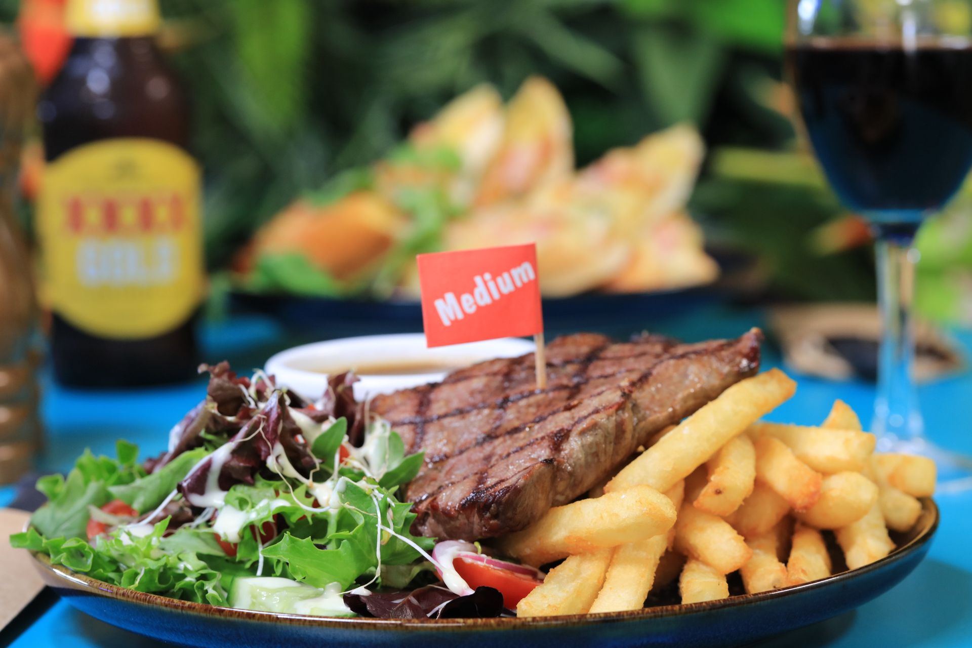 A plate of food with a medium steak and some hot chips