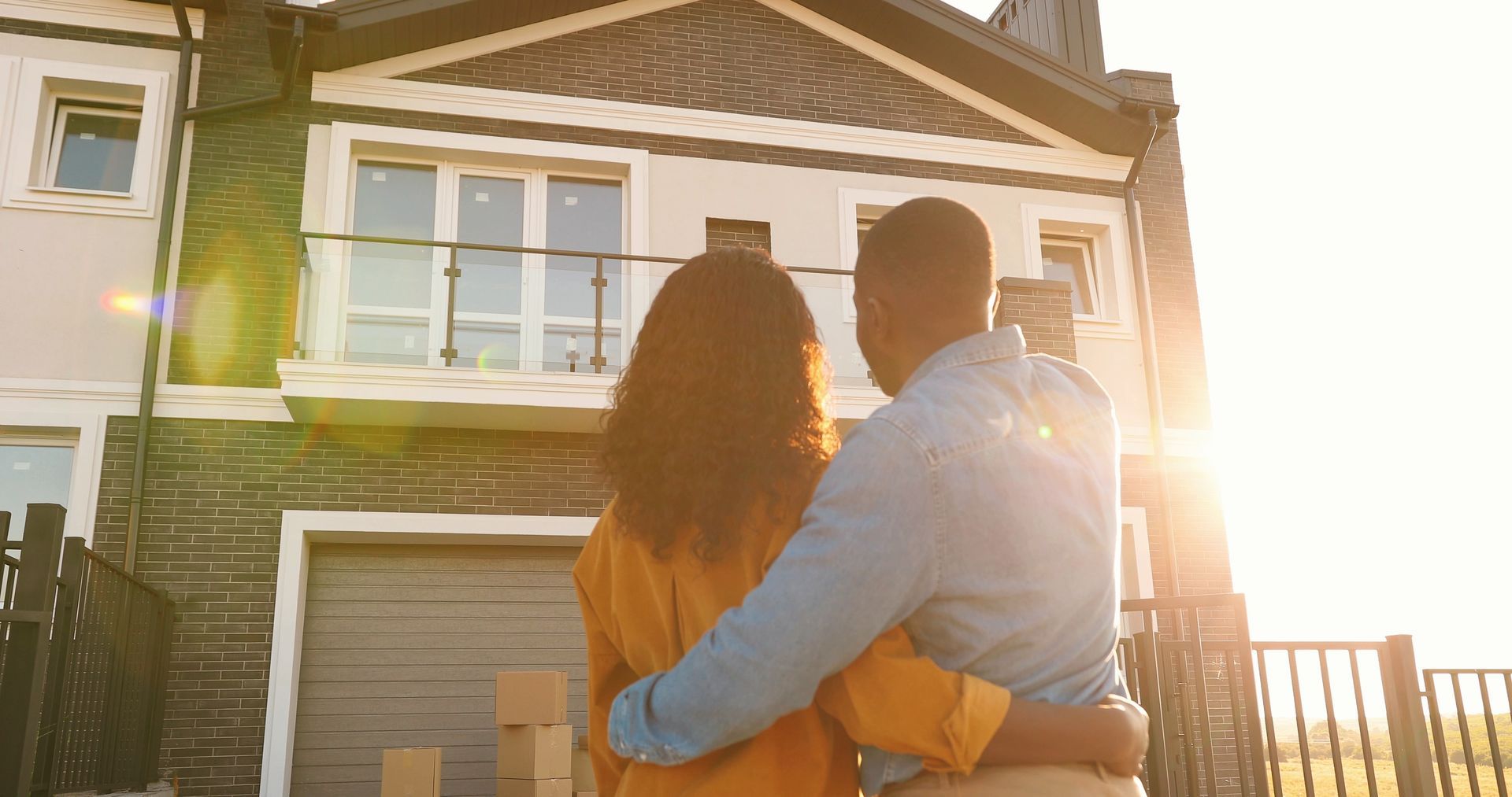 Couple embracing, looking at a house bathed in sunlight. Couple embracing, looking at a house bathed in sunlight.