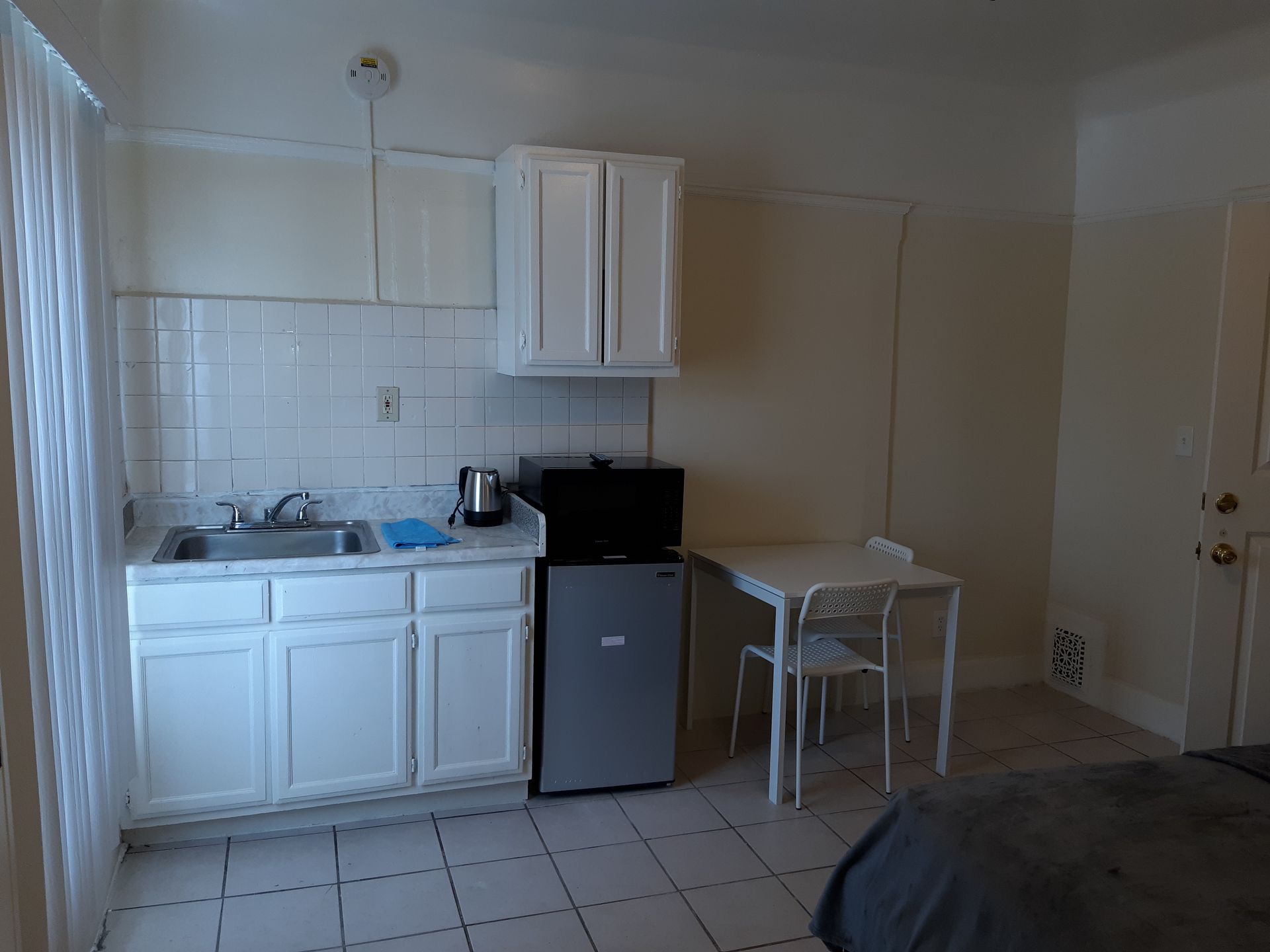 A small kitchen with a sink , table and chairs