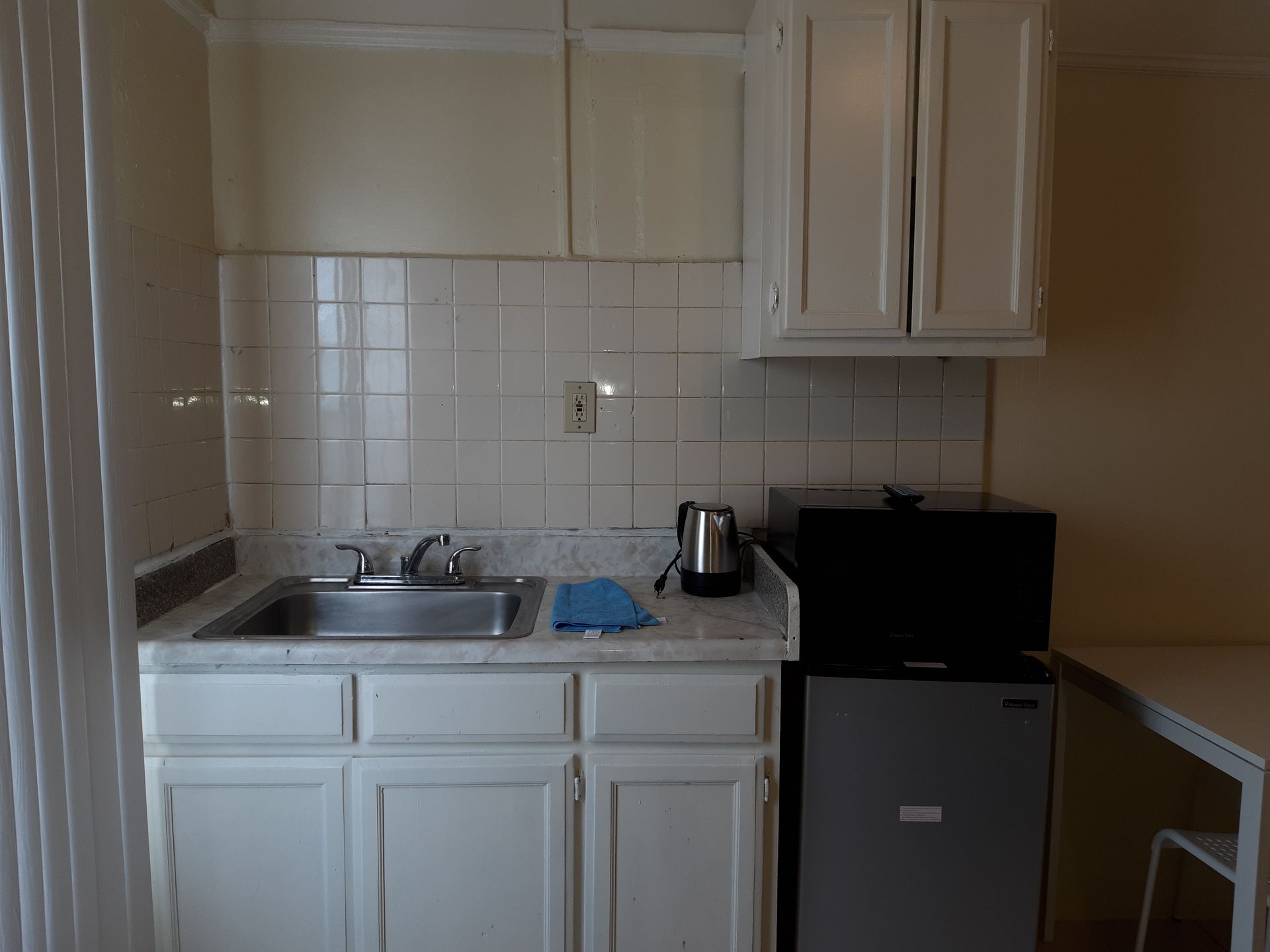 A kitchen with a sink , microwave , and refrigerator