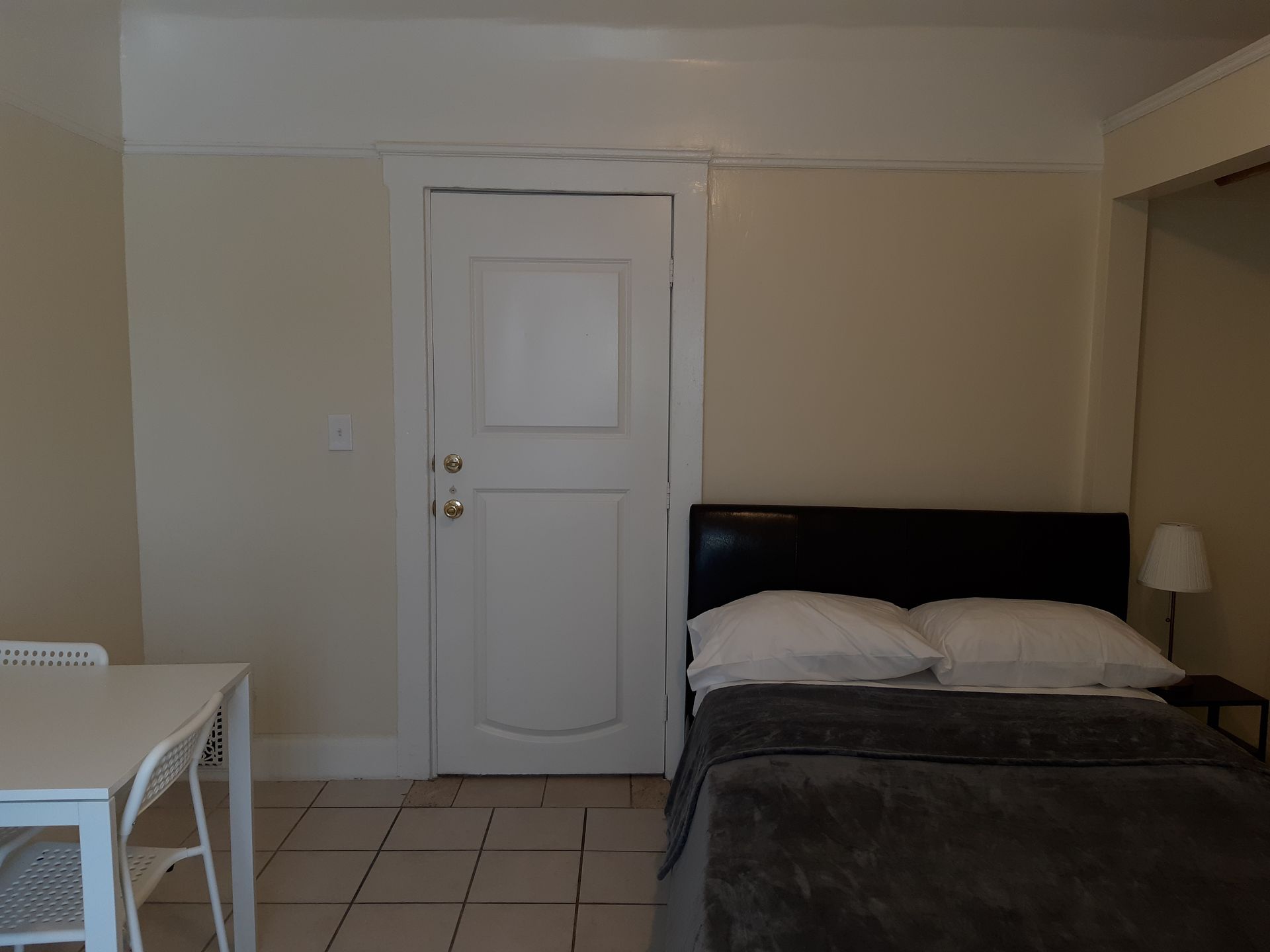 A bedroom with a bed and a table and chairs